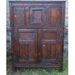 An antique oak duadarn, the upper panelled section fitted with a cupboard, the base with a pair of