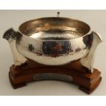 A silver Arts and Crafts style circular bowl, with three lug feet and hammered finish, Chester 1912,