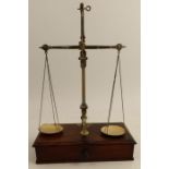 A set of 19th century gilt metal pan scales, on a mahogany base fitted with a drawer, together