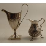 A Georgian silver helmet shaped cream jug, with engraved decoration, raised on a square foot, London