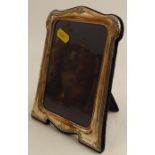 A hallmarked silver mounted photograph frame, with embossed decoration and easel back, aperture size