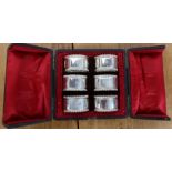 A cased set of six silver napkin rings, with gadrooned edge, each numbered and engraved with an