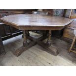 A large octagonal oak dining table, raised on 4 turned legs. W 53 ins, height 28.5 ins