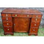 An Edwardian desk, with cross banded decoration, fitted with a central frieze drawer flanked by