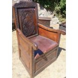 An antique oak box chair, with carved decoration to the box base and back, with upholstered hinged