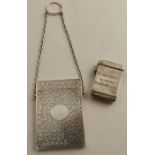 A Victorian silver card case, with engraved ivy decoration, on a chain with finger loop,