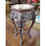 An Oriental hardwood jardiniere stand, the octagonal top inset with marble and having a bead edge,