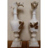 A pair of alabaster urns, the spouts carved with stylised birds heads, with leaf decoration and