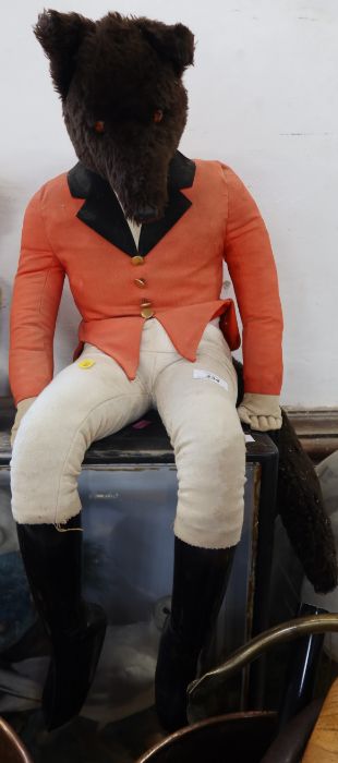 A plush toy fox, dressed in hunting pink, jodphurs and boots together with another toy fox