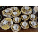 A collection of Dresden cabinet cups, saucers, plates and a tray, decorated with alternate panels of