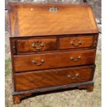 An antique mahogany bureau, the sloping fall flap opening to reveal cupboards, drawers and pigeon