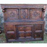 An antique oak court cupboard, fitted with two cupboards to the upper section, and a central