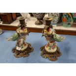 A pair of modern continental porcelain and gilt metal candlesticks, the stems formed as parrots