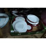 A collection of Royal Worcester dinnerware , with red border together with a platter and soup