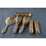 A silver five piece dressing table set, decorated with cherubs, together with an oblong tray