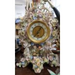 A porcelain mantel clock, encrusted with flowers and two figures - Key and pendulum in base.  The