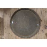 A circular brass tray, with engraved decoration, diameter 23.5ins