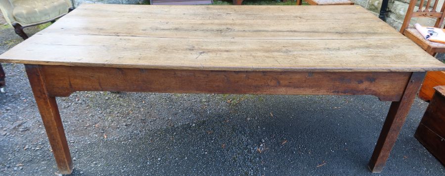 An antique oak farmhouse kitchen table, the three plank top raised on square legs, 85ins x 44ins,