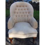 A Victorian spoon button back armchair, raised on short turned front supports