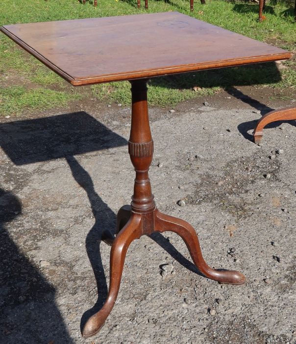 A 19th century mahogany square tilt top table, raised on a turned column and three outswept
