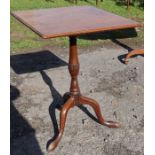 A 19th century mahogany square tilt top table, raised on a turned column and three outswept