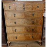 A walnut veneered chest, consisting of a bank of two drawers flanked by a drawer, over four long