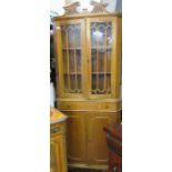 A freestanding glazed corner cabinet