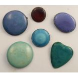 Five Ruskin pottery cabochon plaques, mounted as brooches, together with another unmarked cabochon