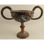 A Cantagalli style pottery two handled pedestal cup, the interior decorated with putti picking