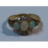 An 18ct gold three stone opal and diamond ring