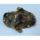 A Victorian yellow metal engraved scroll brooch, set with three garnets and six pearls