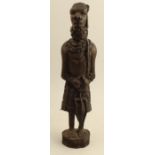 A carved wooden African figure, together with another cast figure holding a shield
