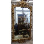 A 19th century gilt framed wall mirror, the frame decorated with flowers and scrolls, overall size