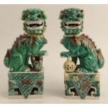 A pair of Chinese famille vertes Shi Shi figures, raised on rectangular bases, height 7.5ins - One