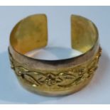 A gold cuff bangle, with stylised raised frieze, 28g