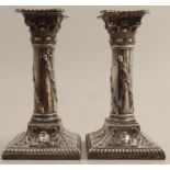 A pair of silver candlesticks, with Corinthian capitals, embossed with swags of acorns and oak