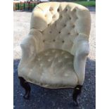 A Victorian upholstered button back armchair, raised on short carved front supports