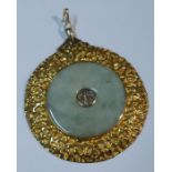 A large jadeite disc pendant, set with characters to the center and mounted in a textured yellow