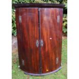 A 19th century mahogany barrel front corner cupboard, fitted with shelves, height 39.5ins, width