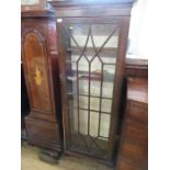 A 19th century narrow bookcase with astragal glazed bars opening to revea l shelves raised on