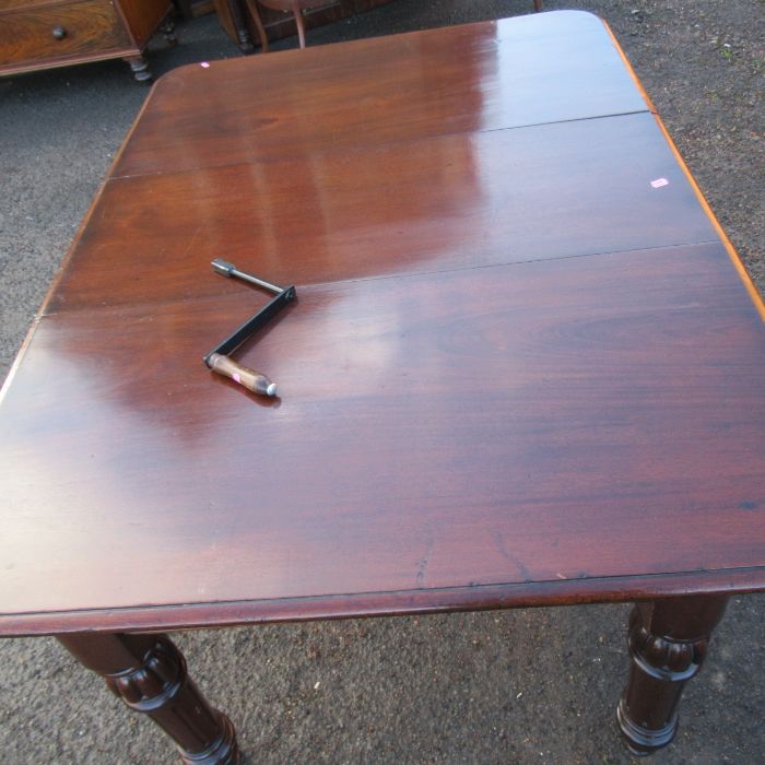 A 19th century mahogany wind out dining table, raised on turned legs, with one leaf, open length - Image 2 of 2