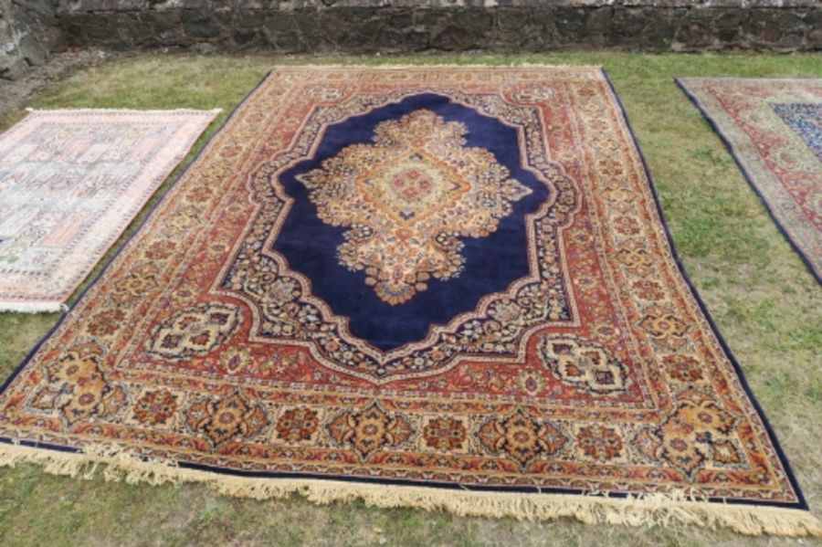 A modern Eastern design rug, the blue ground decorated with a central stylised medallion, 135ins x