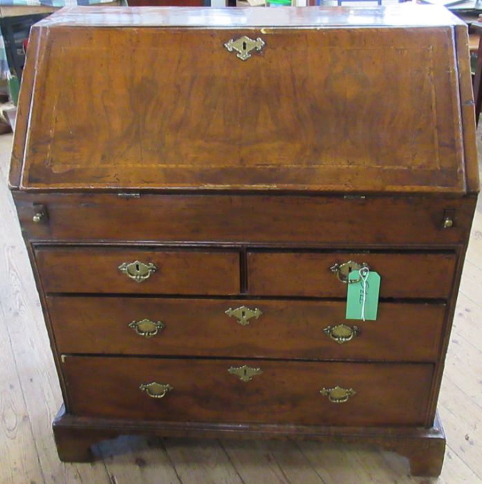 An Antique walnut bureau, with feather banding, the fall flap revealing pigeon holes and drawers