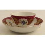 A Worcester tea bowl and saucer, later decorated with the Hope Edwards pattern of flowers, fruits