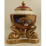 A porcelain covered centre piece, the pierced cover decorated in burgundy and gilt, the body with