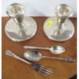 A pair of silver dwarf candlesticks, together with silver Apostle teaspoons and a silver plated