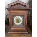 An Edwardian mantel clock, the chiming movement marked Junghans A06, in a carved wooden case, height