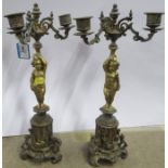 A pair of gilt metal candelabra, the columns formed as putti, together with a pair of oil lamps with