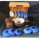 A Le Creuset Blue Enamel Five Pan Set on stand, Le Creuset brown enamel fondue set and other cast