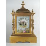 A French 19th Century Gilt Brass Mantle Clock with a hand painted porcelain dial decorated with